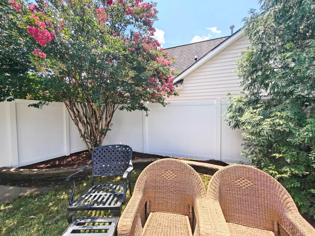 Clean white vinyl fence and tidy backyard seating area in Concord, NC after fence washing
