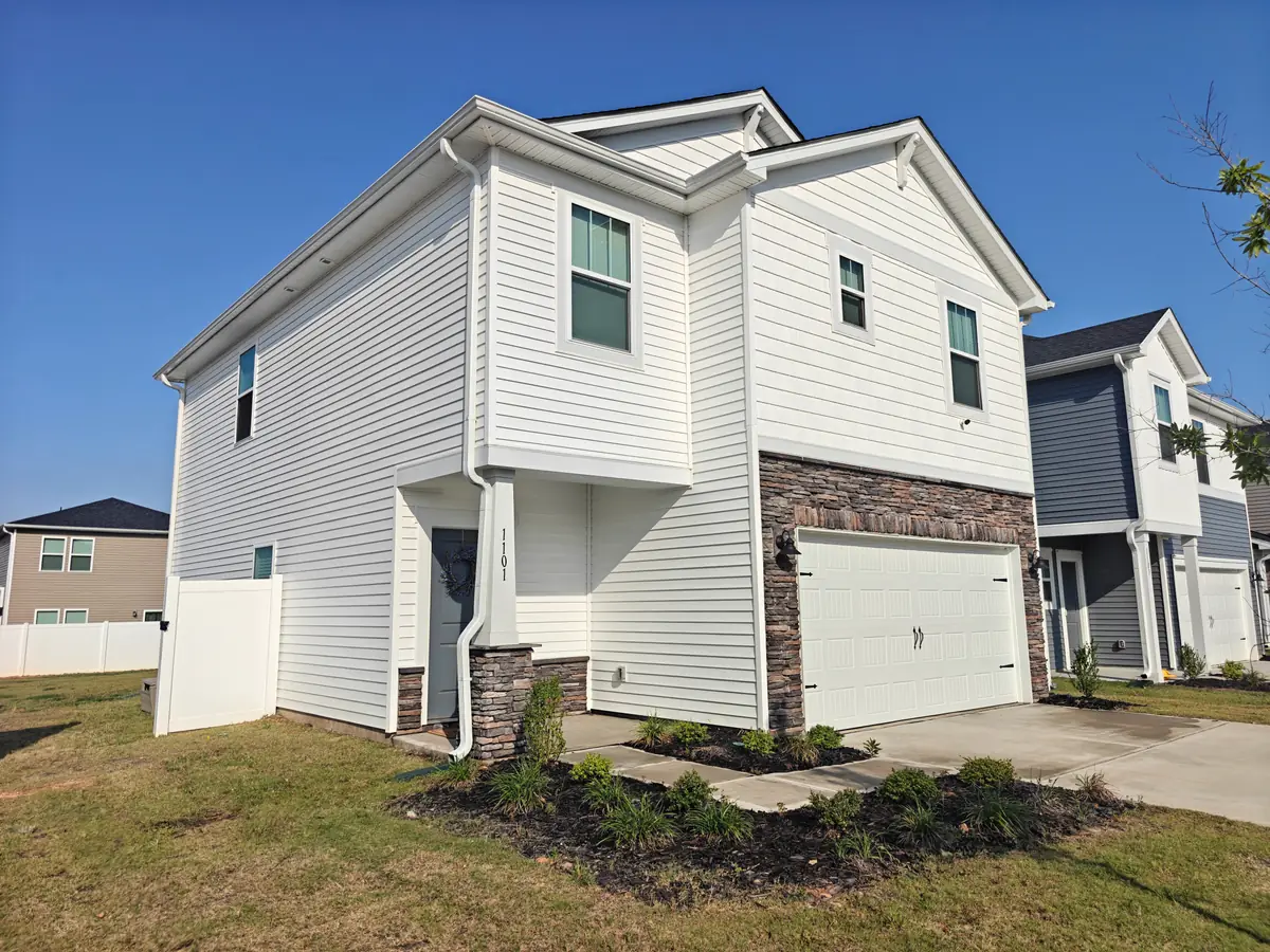 Two-storey home in Albemarle, NC with white vinyl siding and stone accents, cleaned by a Soft Touch Softwash soft wash