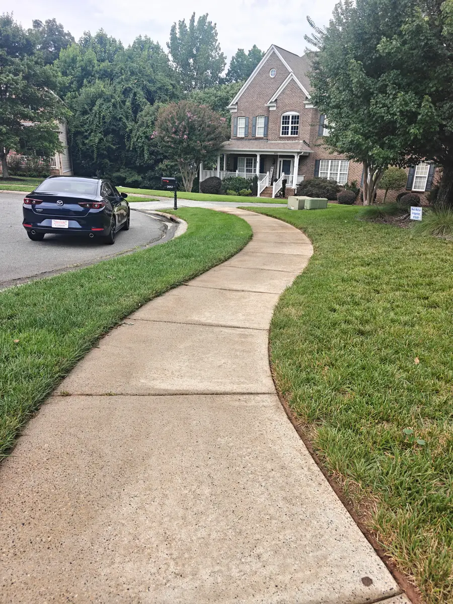 The same front walkway after pressure washing, cleaned to an even grey finish